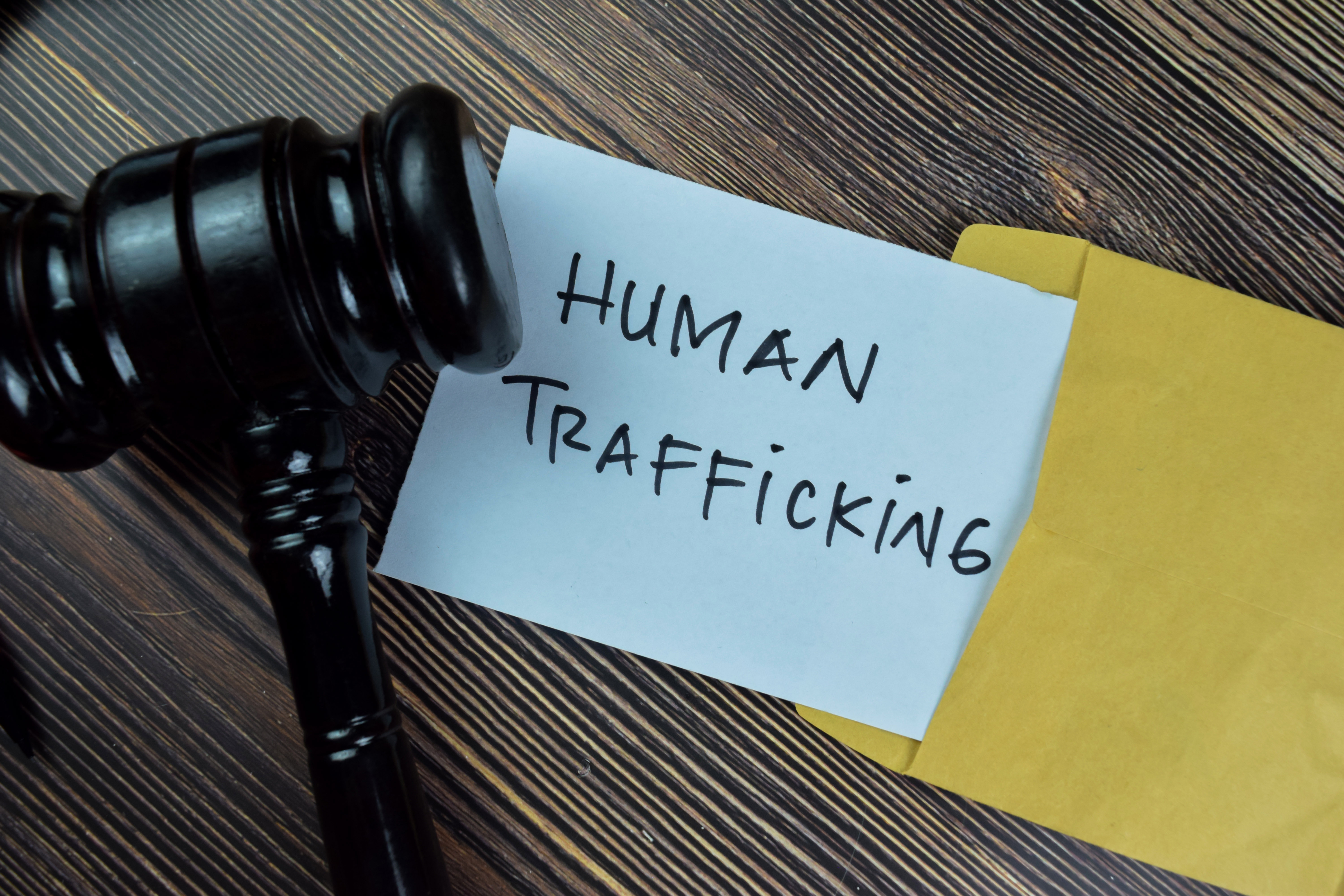 Human trafficking text on document with gavel